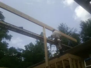 Carpenter setting a ridge beam over a new addition frame — Ice Dam Removal by Roofing Brothers in Martinsdale