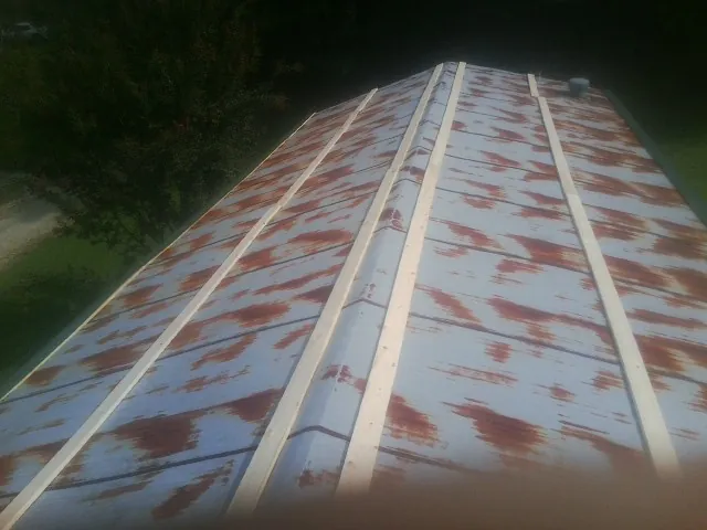 Rusted metal roof panels with new wood purlins before replacement — Storm Damage Roof Repair in Martinsdale by Roofing Brothers