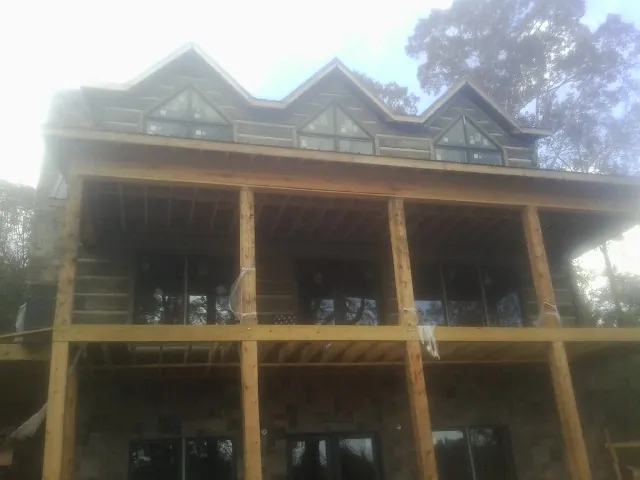 Dormers and porch framing on a large log home under construction — Roof Coating work by our crew in Martinsdale
