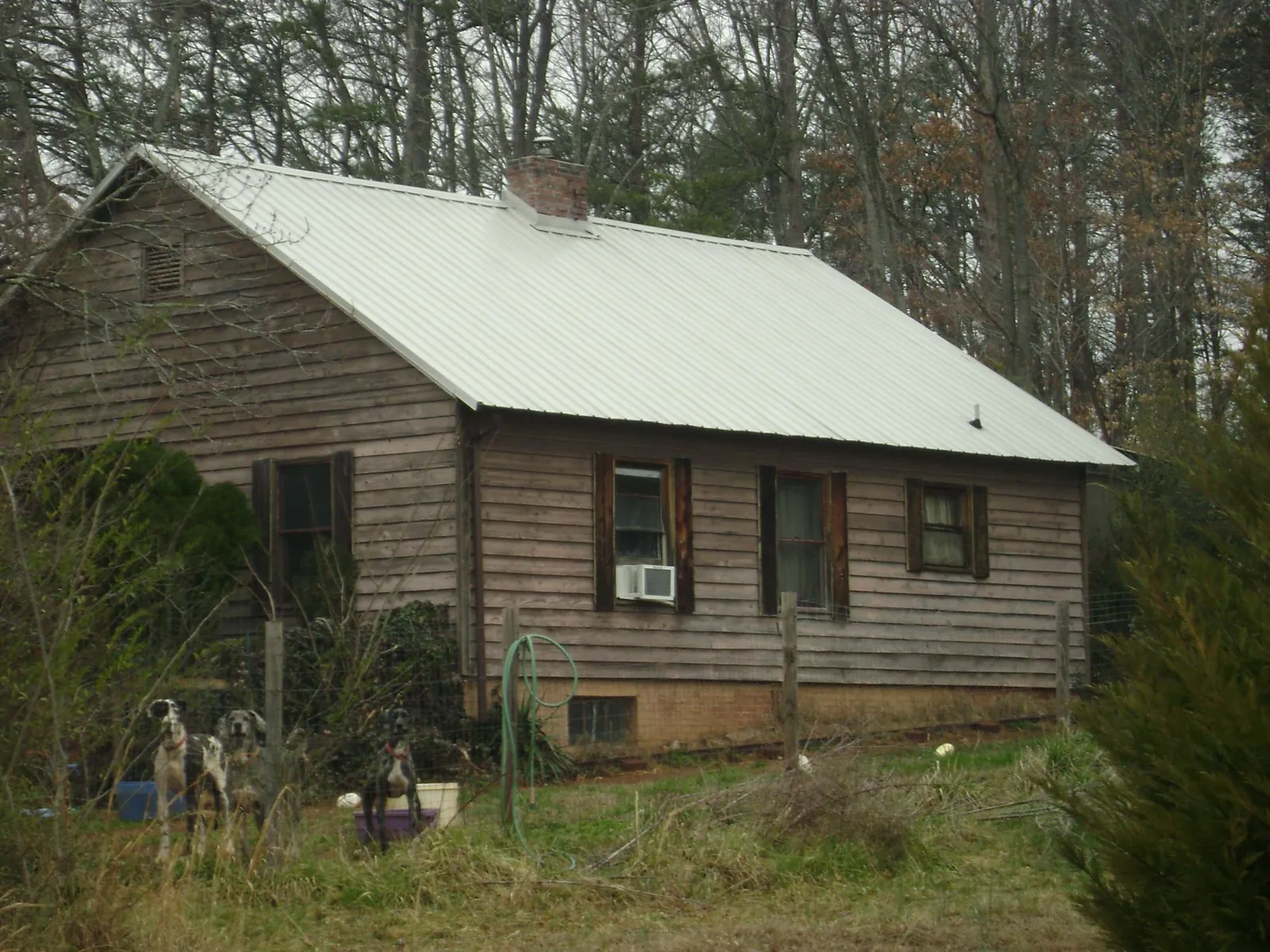 White metal roof on an old wood sided farmhouse, from a Metal Roof Installation job in Martinsdale